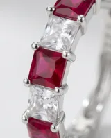Caravanas de plata con diseño de aro pequeño, adornadas con una hilera de circonias blancas y fucsias en corte baguette.