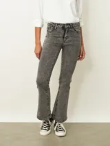 Jean de corte oxford en color negro, con tiro medio y ajuste en la cintura y caderas, ensanchándose desde la rodilla hacia el ruedo.