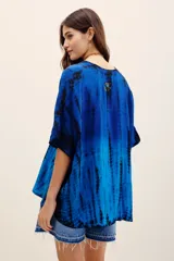 Camisa de viscosa con estampado tie-dye en tonos de azul y negro, de manga corta, cierre frontal con botones y bordados decorativos en el frente.