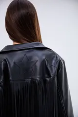 Campera de cuero sintético negro con flecos largos en la espalda y mangas. Presenta un diseño de estrellas pespunteadas en la parte superior de la espalda.