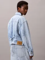 Campera de jean estilo cropped con lavado claro, cuello en punta, cierre frontal con botones metálicos y doble bolsillo en el pecho. Presenta un diseño clásico con costuras reforzadas y parche con logo de la marca.
