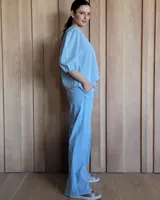 Pantalón de denim azul, de corte recto y tiro alto, con cintura elástica y cordón ajustable. Tiene bolsillos laterales.