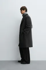 Abrigo regular fit de color negro, confeccionado con mezcla de lana y cashmere. Presenta cuello con solapas de muesca, manga larga, bolsillos de vivo en la cadera, abertura central en la espalda y cierre frontal de botonadura con tres botones.