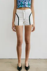 Short de jean color crudo con apliques de cuero sintético negro en los laterales.