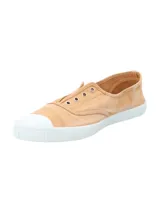 Zapatilla tipo sneaker de diseño ligero y fresco, confeccionada en algodón orgánico teñido a mano en tono arcilla. Presenta puntera reforzada de goma blanca, suela de caucho natural y ojales metálicos decorativos.