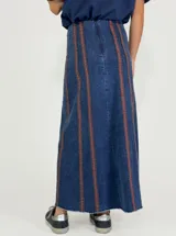 Pollera larga de jean azul con rayas verticales verdes.