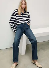 Jeans de tiro medio color azul oscuro, con diseño recto, cinco bolsillos, trabillas y cierre delantero con cremallera y botón.