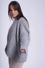 Sweater oversize tejido en punto trenzado color gris, con cuello redondo y mangas largas.