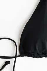 Top de bikini triangular color negro con relleno extraíble y tiras para atar en el cuello y la espalda.