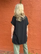 Blusa de manga corta color negro, con frente de seda y espalda de viscosa con elastano, de diseño básico y elegante.