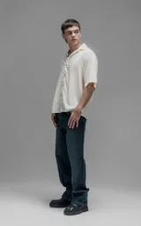 Camisa de manga corta con cuello cubano y cierre frontal de botones, de corte oversize y diseño minimalista.