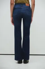 Pantalón de jeans azul oscuro, corte bootcut, tiro medio y calce slim desde la cintura hasta la rodilla.