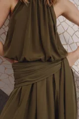 Top globo color verde militar, con escote halter alto y fruncido, diseño sin mangas y bajo abullonado con brillo sutil.