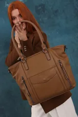 Cartera tipo tote de diseño estructurado en símil cuero, con doble asa rígida y correa regulable. Presenta múltiples bolsillos frontales con cierre y solapa, ofreciendo un estilo versátil y espacioso.