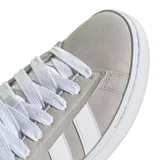 Championes urbanos Adidas modelo Grand Court Alpha, color gris con detalles en blanco. Presentan un diseño inspirado en el tenis clásico, confeccionados en material sintético tipo nobuk, con las icónicas tres tiras laterales, cierre de cordones y suela de goma con tecnología Cloudfoam para mayor amortiguación.