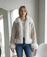 Campera de gamuza sintética en color crudo, con interior y detalles de piel sintética blanca en cuello, solapas, ruedo y puños. Presenta cierre frontal y bolsillos laterales con cierre.