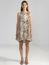 Vestido corto sin mangas, con corte en A, escote redondo y bajo redondeado con dobladillo asimétrico. Presenta un diseño estampado que combina motivos de animal print de leopardo y cebra.