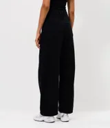 Pantalón de jean con corte barrel, de tiro medio y piernas anchas. Presenta un lavado marmorizado, trabillas en la cintura, cierre frontal con botón y cremallera, bolsillos funcionales y recortes decorativos en las rodillas.