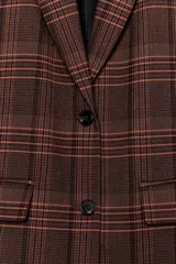Blazer Zara de cuello solapa y manga larga, con estampado de cuadros en tonos marrones y rojizos. Presenta cierre frontal con dos botones y bolsillos delanteros con solapa.