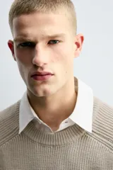 Jersey de punto con diseño boxy fit, cuello redondo y manga larga. Presenta una textura acanalada y acabados en rib en puños y ruedo.