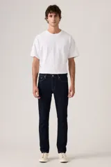 Jean de corte slim fit en color azul oscuro, con diseño clásico de cinco bolsillos, cierre de cremallera y botón metálico.