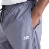 Pantalón New Balance Sport Legacy, diseño bicolor en tonos gris y azul marino, con cintura elástica ajustable mediante cordón y logo bordado en blanco.