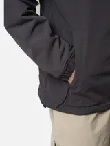 Canguro tipo anorak de color gris oscuro, con capucha ajustable, bolsillo frontal con solapa y cierre de media cremallera. Presenta detalles en color naranja en los tiradores de los cierres y un parche con el logo de la marca en el centro del pecho.