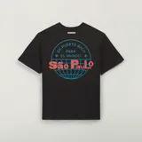 Remera negra Adidas de manga corta, corte clásico y cuello redondo. Presenta un gran gráfico estampado en la espalda que combina un mapamundi circular en líneas celestes con texto en turquesa y letras rojas grandes superpuestas.