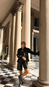 Bermuda de tiro alto confeccionada en cuerina negra, con corte recto y largo hasta la rodilla.