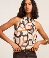 Blusa de chiffon sin mangas con cuello halter y estampa geométrica de eslabones en tonos marrones y negros. Presenta fruncido en el escote y diseño fluido.