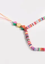 Correa para celular con cuentas de látex de colores y dijes de frutas y ojo turco.