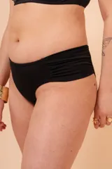 Bombacha de bikini tiro alto color azul marino, con frunce en los costados. Confeccionada con tela que contiene fibra LYCRA® XTRA LIFE™.