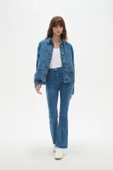 Sobrecamisa de jean azul con cierre frontal de botones metálicos, bolsillos frontales y detalle de bordado inglés en el ruedo.