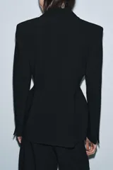 Blazer entallada de Zara Woman Collection, color negro, con cuello solapa de muescas, manga larga con botones en puños y cierre frontal con botones. Presenta bolsillos de vivo en el delantero y detalle de pespuntes marcados a tono.