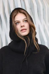 Capucha de tejido de punto con cuello amplio y cordón de ajuste, diseñada para cubrir la cabeza y el cuello de manera envolvente.