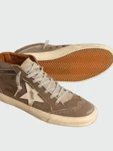 Zapatillas de caña media Golden Goose, color marrón con efecto desgastado. Presentan una estrella lateral de cuero en tono claro, cordones al tono y suela de goma con acabado envejecido.