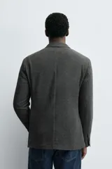 Blazer slim fit de estructura con diseño de pata de gallo, cuello con solapas de muesca, manga larga con botones en puños, bolsillos de solapa en cadera y cierre frontal con botones.