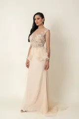 Vestido largo de fiesta color champagne, con corset de tul bordado con transparencias y falda de plumeti con cola.