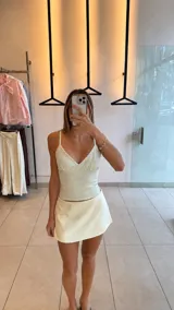 Top corto de tirantes finos, con escote en V y diseño ajustado, con estampado a cuadros en tonos marrones y blancos.