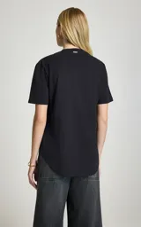 Remera de algodón negra, de corte recto y holgado, con escote redondo, mangas cortas y detalle frontal de banda retorcida con lazo y drapeado.