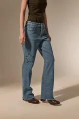 Pantalon de jean azul de corte recto y calce medio, con bordados de estrellas y detalles de pequeñas tachas.
