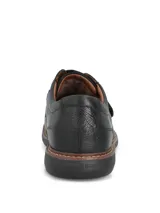 Zapatos de cuero negro Hush Puppies modelo Iowa, con cierre de tira de velcro en el empeine, costuras visibles en la suela y suela de goma EVA.