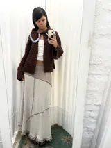 Falda larga de algodón con diseño de paneles en tonos beige y marrón, con costuras visibles y detalles de flecos en el ruedo.
