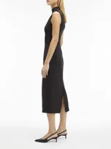 Vestido midi negro de punto técnico con corte entallado, cuello perkins, cremallera trasera, sin mangas, recortes en forma de media luna en los hombros, detalles de costuras verticales en la parte frontal y posterior, y hendidura en la espalda.