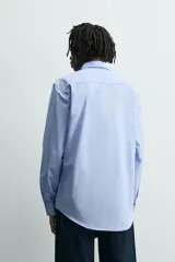 Camisa slim fit de algodón color celeste, con cuello italiano, manga larga y puños con botón. Cierre frontal de botonadura.