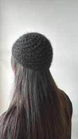 Gorro negro de tejido calado con textura brillante.