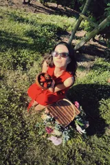 Vestido corto sin mangas de color rojo, con escote en V y detalle de alforzas verticales en el frente. Presenta un diseño de silueta relajada y fluida.