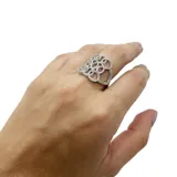 Anillo plateado con diseño calado y circonitas incrustadas.