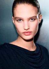 Top de manga larga en color negro, con diseño recto y cuello drapeado. Confeccionado en tejido fluido con acabado ligeramente satinado.