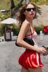 Shorts globo de tiro medio en tejido satinado rojo, con cintura elástica ajustable con cordón y detalles de encaje a contraste en los laterales.